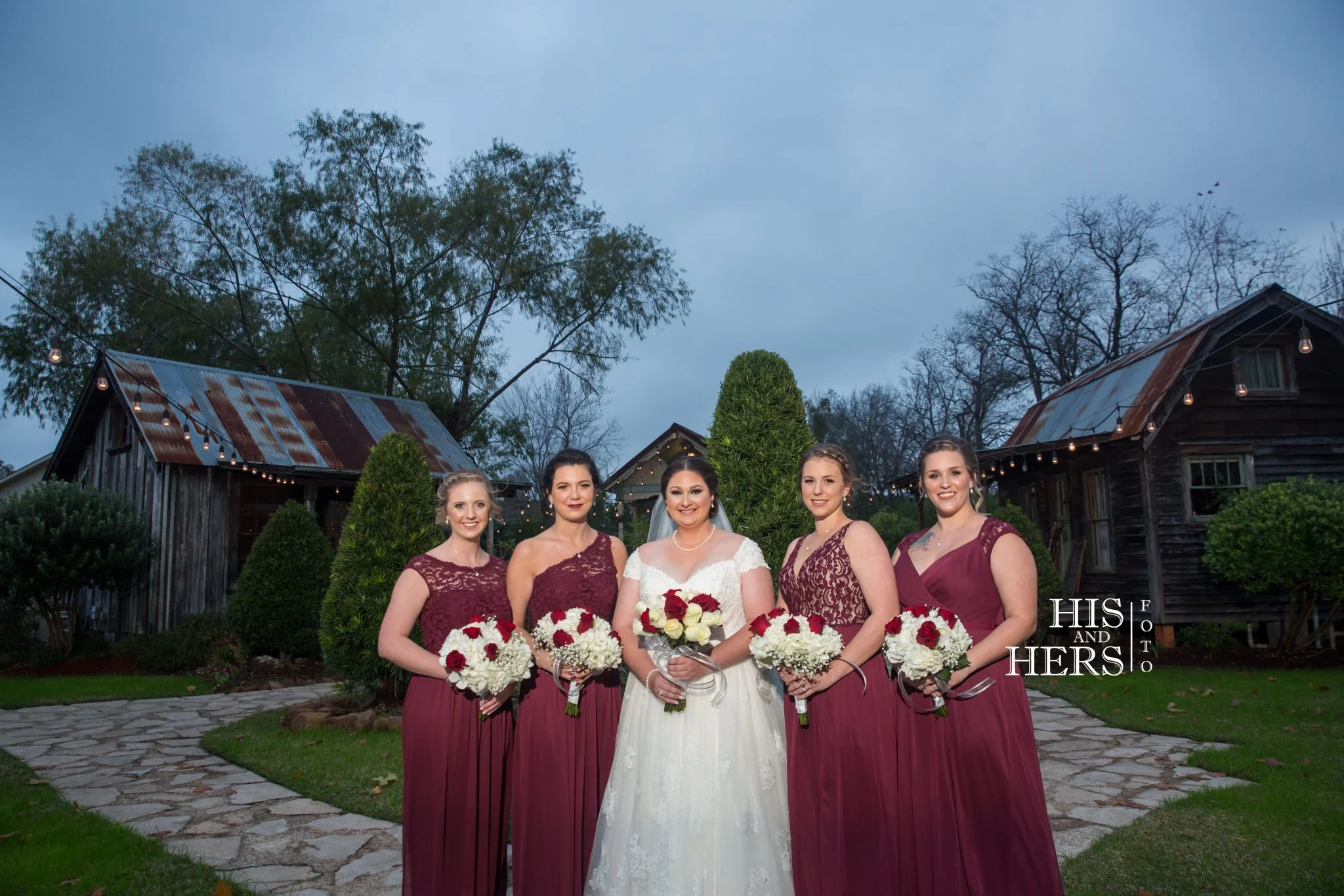 Kristen with her bridesmaids in burgundy by the rustic barns