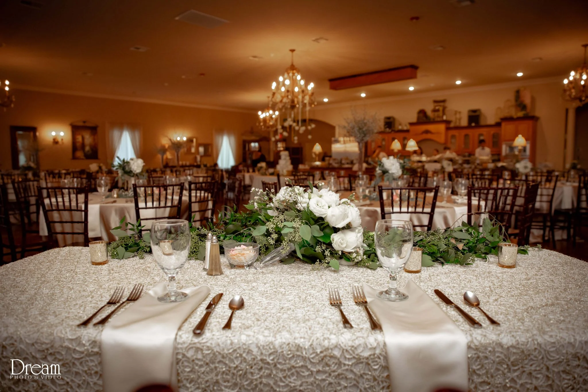Banquet hall set with rose runners and chandelier light